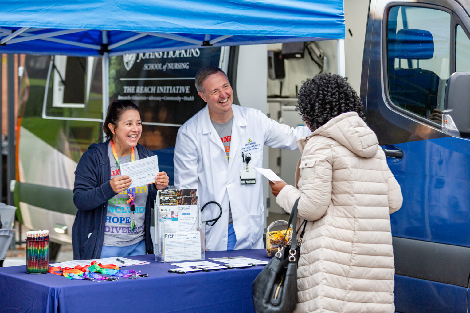 Dr. Jason Farley and teammember consult a patient testing for infectious diseases at their mobile testing site.